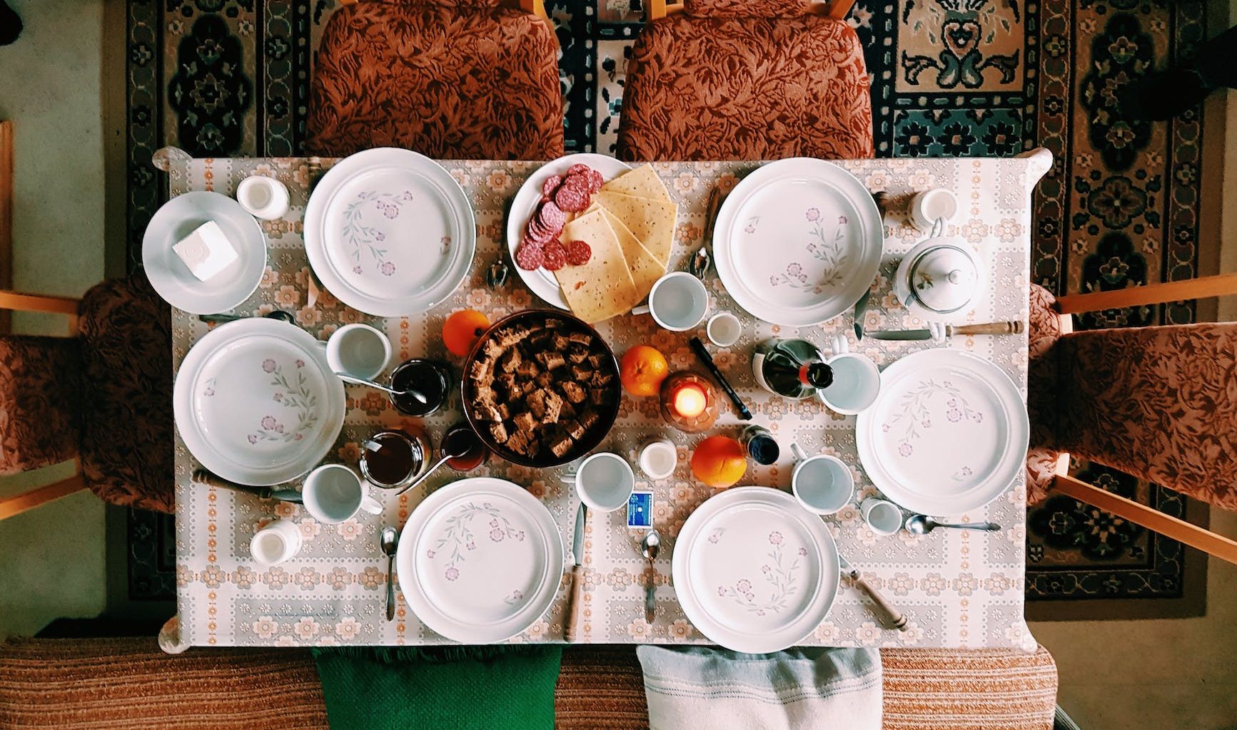 high angle photography of dinner set on table surrounded with padded chairs